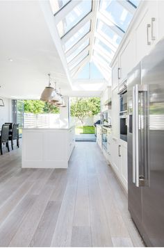 an open kitchen with white cabinets and stainless steel appliances, is seen in this image