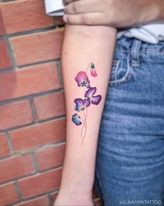 a woman's arm with purple flowers on it