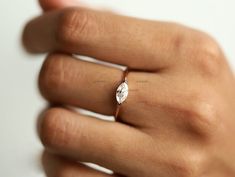 a woman's hand with a diamond ring on top of her finger, showing the center stone