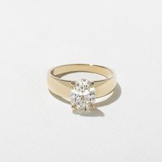 a yellow gold ring with a single diamond on the top and bottom, against a white background