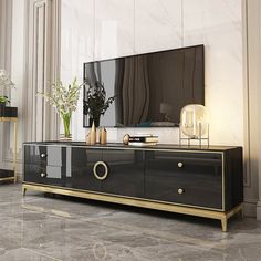 a black and gold tv stand in a living room with two vases on it