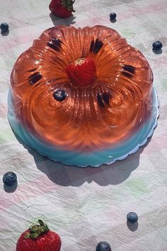 a cake sitting on top of a table next to strawberries