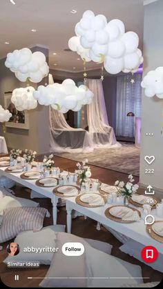 a table set up for a party with white balloons