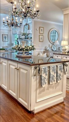 a kitchen island with towels hanging on it's side and a chandelier in the background