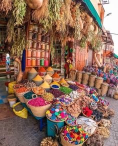 an outdoor market with lots of different types of foods and spices on display in baskets