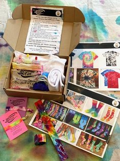 an open box on a bed with various items inside it and instructions for making tie - dyed t - shirts