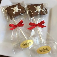 four chocolate lollipops wrapped in cellophane and tied with red ribbon