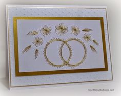 a card with two wedding rings on the front, and gold trimming around the edges