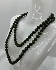 Discover the exquisite Vintage Jade Necklace, a true gem for lovers of high-quality jewelry. With an impressive length of 80 cm and a pearl diameter of 0.7 cm, this necklace offers a remarkable presence. Each of the jade pearls radiates a deep, rich green color that adds a touch of sophistication to any outfit. The necklace weighs a total of 83.26 grams and impresses with its high-quality workmanship and timeless design. This necklace has a practical twist clasp that ensures a secure hold and is Elegant Jade Necklaces With Round Beads, Elegant Round Jade Beaded Necklaces, Elegant Round Jade Beads, Formal Single Strand Jade Necklace, Classic Jade Necklaces With Round Beads, Classic Jade Necklace With Round Beads, Elegant Jade Beaded Necklace With 8mm Beads, Elegant Long Necklace With Round Natural Stones, Formal Green Pearl Necklace With Round Beads