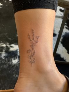 a woman's foot with a flower tattoo on it