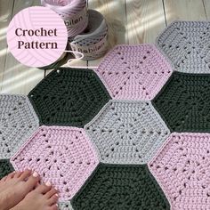 a crocheted hexagon rug is on the floor next to yarn balls