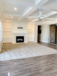 an empty living room with wood flooring and white painted walls on either side of the fireplace