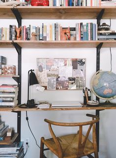 a wooden chair sitting in front of a book shelf filled with books