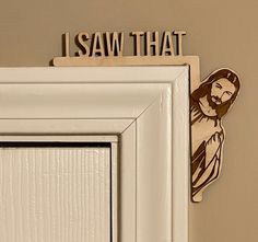 a wooden sign that says i saw that above a door with a jesus image on it