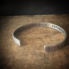 "This custom bracelet is hand stamped with your personalized wording. It is a skinnier version of my popular \"I am...loved\" bracelet. This little beauty is approximately 1/4 inch wide. Remind yourself (or someone special) how great you really are. This bracelet is stamped with a discreet \"I am...\" on the bottom of one side, and \"loved\" on the other. The inside of the cuff holds up to 5 words of your choice of words. Customize it your way! The outside of the bracelet has a gently textured f Adjustable Everyday Jewelry With Custom Text, Adjustable Custom Text Jewelry For Everyday Wear, Inspirational Engraved Bracelets For Everyday, Meaningful Hypoallergenic Bracelet For Best Friend Gift, Inspirational Engraved Everyday Bracelets, Everyday Inspirational Engraved Bracelets, Customizable Meaningful Bracelets For Everyday, Personalized Meaningful Name Bracelet, Personalized Promise Bracelet With Meaningful Style