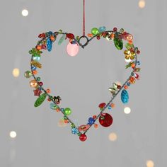 a heart shaped ornament hanging from a string with lights in the back ground