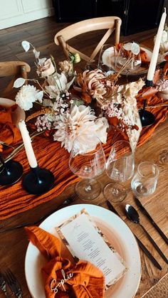 the table is set with an orange cloth and place settings for two people to sit at