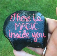 a hand holding a rock that says there is magic inside you