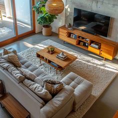 a living room filled with furniture and a flat screen tv on top of a wooden stand