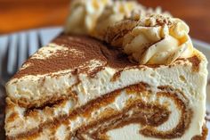 a close up of a piece of cake on a plate with whipped cream and chocolate