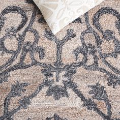 a close up of a rug with a pillow on top of it and an area rug behind it