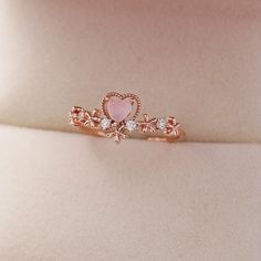 Add a touch of sweetness to any look with the Bridget Ring. Featuring an eye-catching heart design set in a delicate pink hue, this cute accessory adds a romantic touch to any wardrobe. 📌 Please Note: When adjusting the ring, please squeeze or expand the ring body slowly and gently. 💎 Materials: 14k Rose Gold Electroplated - more durable than regular platings Cubic Zirconia 📐 Size: Adjustable Open Design - Size 5+ Rose Gold Crystal Promise Ring For Valentine's Day, Dainty Rose Gold Heart Ring For Proposal, Rose Gold Flower Ring For Valentine's Day, Pink Open Ring Jewelry For Valentine's Day, Feminine Pink Rings For Gift, Dainty Pink Heart Promise Ring, Rose Gold Heart-shaped Midi Rings For Valentine's Day, Adjustable Pink Rings For Proposal, Dainty Pink Gold Rings For Valentine's Day