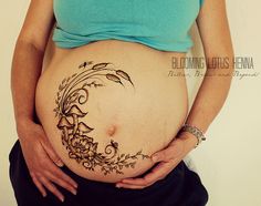 a pregnant woman's belly with flowers and leaves drawn on the side, in front of her stomach