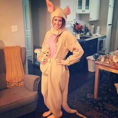 a woman in a bunny costume standing next to a couch