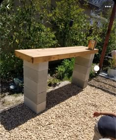 a bench made out of cinder blocks sitting on gravel