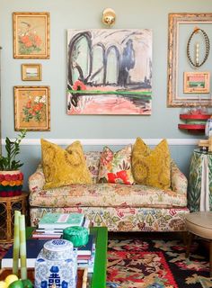 a living room filled with furniture and pictures on the wall above it's coffee table