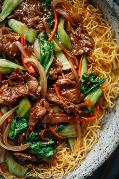 beef and vegetable stir fry with noodles in a bowl