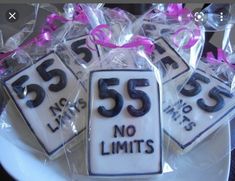 some cookies that have numbers on them and ribbons tied around the top are sitting on a plate