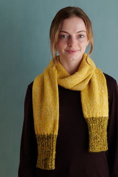 a woman wearing a yellow scarf and brown sweater