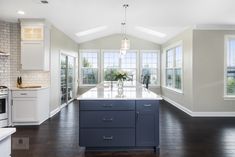 a large kitchen with an island in the middle and lots of windows on both sides