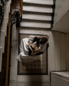 a bride and groom laying down on the stairs