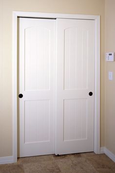 an empty room with two white doors in it