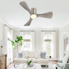 a living room filled with furniture and a ceiling fan in the middle of the room