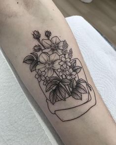 a black and white photo of flowers in a vase tattoo on the left forearm, right arm