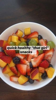 a white bowl filled with fruit on top of a wooden table