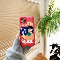 a person holding up a phone case with cartoon characters on it