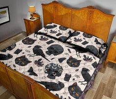 a bed with black cats on it and two night stands in the corner next to it