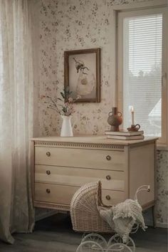 a baby's crib in the corner of a room with floral wallpaper