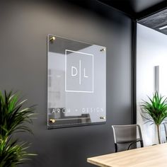 a glass sign hanging on the side of a wall next to a potted plant