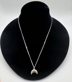 a black mannequin with a silver necklace on it