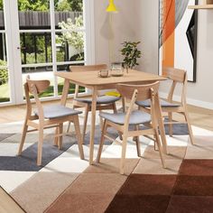 a dining room table with chairs and a rug on the floor