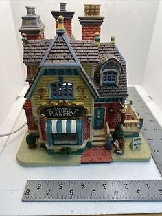 a small toy house with a ruler on the table