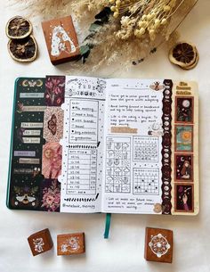 an open book with stamps and some other items on it next to dried flowers, wheat stalks