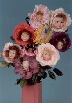 a vase filled with lots of flowers and babies'heads on top of each other