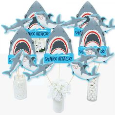 Bring your party theme to all areas of the celebration with Shark Zone Baby Shower or Birthday Party Table Toppers. Each heavy-duty card stock paper cutout quickly attaches to the included sticks to create centerpiece sticks that can be used in vases or floral arrangements at all your party tables. You can even add them to candy jars at your goodie table! Shark Zone centerpiece sticks may also be used as photo booth props. You will love how versatile this fun party supply is while your guests wi Jawsome Shark, Graduation Party Pictures, Shark Themed Party, Shark Themed Birthday Party, Candy Birthday Party, Shark Birthday Party, Birthday Party Centerpieces, Party Centerpiece, Birthday Centerpieces