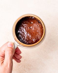 a person holding a cup of coffee in their hand